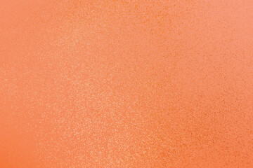 Beautiful light orange background with golden glitter. Holiday decoration concept.