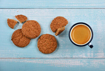 Oatmeal cookies and pannikin of coffee on blue table