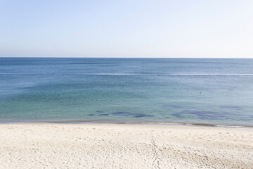 Fototapeta na wymiar Abstract calm blue sea water horizon with light sand beach and sky wild nature beauty 