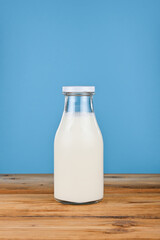 Close up one glass bottle of milk over blue