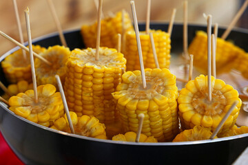 Closeup boiled cooked corn cobs on stick
