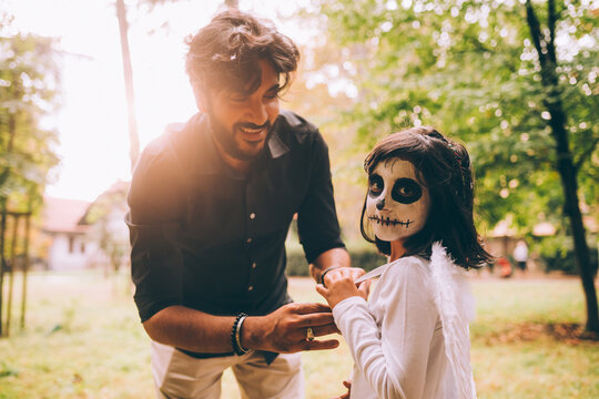 Father helping daughter with Halloween costume