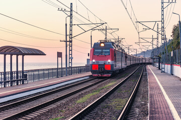 Fototapeta na wymiar Passenger train moves along Black sea coast.. Sochi.