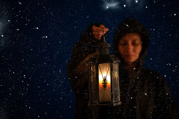 holding lantern on dark winter night