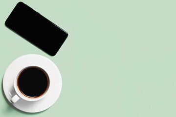 Cup of coffee on a green background. Coffee cup top view.