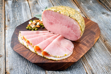 Modern style traditional German boiled Christmas ham with exotically spices and sage offered as...