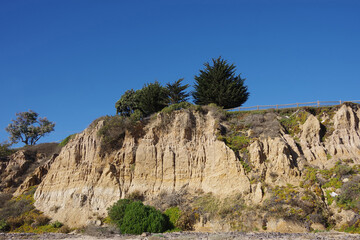 Low angle view of the bluffs and landscape above the pacific ocean beach in Summerland, California on a warm and sunny autumn day