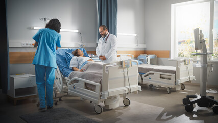 Hospital Ward: Friendly Latin Doctor Consulting Beautiful Female Patient Resting in Bed. Physician...