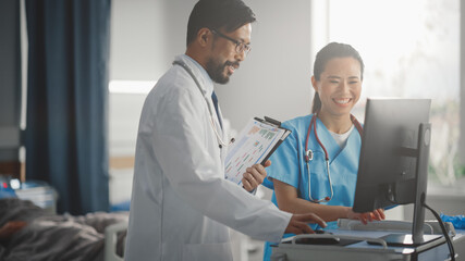 Hospital Ward: Chinese Doctor Talks With Professional Head Nurse, They Use High-Tech Computer. In Background Patient Sleeps in Bed Recovering after Successful Surgery. Health Care Specialists Working