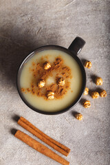 Boza or Bosa, traditional Turkish drink with roasted chickpea in ceramic bowl with cinnamon on...