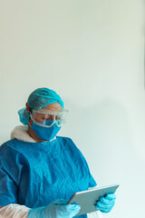 Female doctor with digital tablet in hand. Concept of remote care for patients with coronavirus. A nurse with a medical mask helps patients via the Internet.