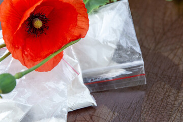 flowers and opium poppy heads next to packages of heroin, soft focus, toning