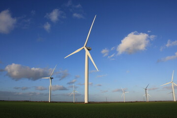 Wind farm turbines that produce electricity energy. Windmill Wind power technology productions Wind turbines standing in green field - stock footage
