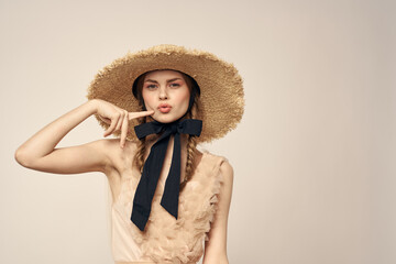 cute girl in straw hat with black ribbon and dress on beige background cropped view