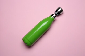 Green thermo bottle on pink background, top view