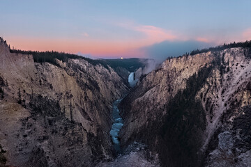 Moon set at sunrise, Lower Falls of the Yellowstone River and Grand Canyon, Yellowstone National Park, Wyoming, USA
