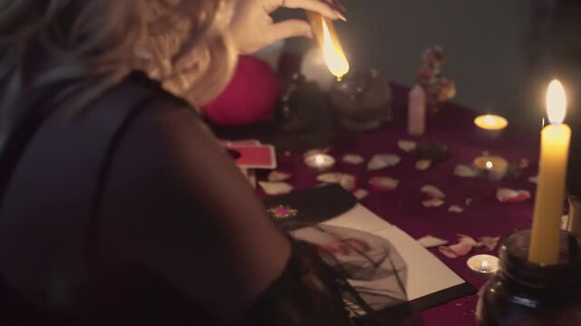 Witch fortune teller psychic dripping paraffin on photo of lost person