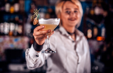 Girl barman creates a cocktail in the taproom