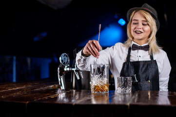 Girl barman mixes a cocktail at the brasserie