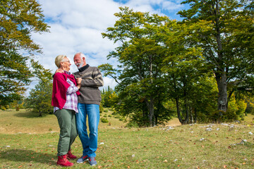 Senior couple on a walk in an autumn nature.