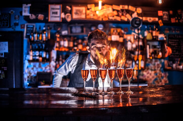 Charming tapster intensely finishes his creation in the bar