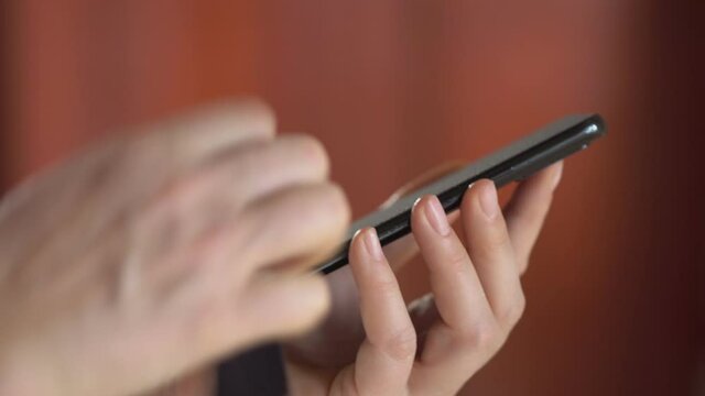 Close-up of woman hand using wet wipe and sanitizer to clean cell phone screen. People cleaning and disinfecting mobile telephone monitor to kill virus and germs. Female hands holding smartphone
