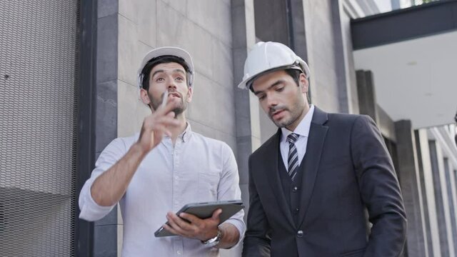 Group Business man and engineer walking Talk work in the building Or office. Use tablet to take note And meeting construction, addition, and amendment to location. Concept key worker teamwork