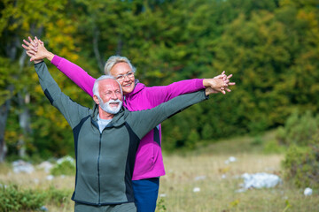 Naklejka premium Happy senior couple smiling outdoors in nature. Grandparents, autumn.