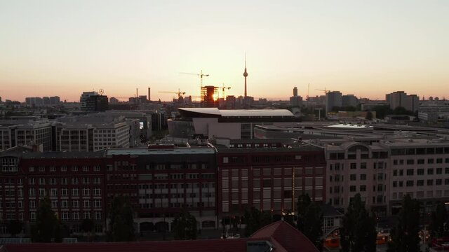 AERIAL: Flight over Berlin, Germany at beautiful Sunset, Sunlight and view on Alexanderplatz TV Tower and Ostbahnhof, Sunflairs