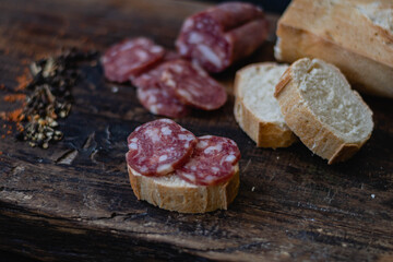 salame de la colonia tipo casero sin cascara con especies pimienta pan sobre madera  cordoba argentina