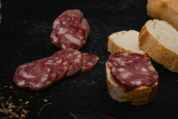 salame de la colonia tipo casero sin cascara con especies pimienta pan sobre madera  cordoba argentina