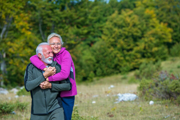 Happy senior couple smiling outdoors in nature. Grandparents, autumn.