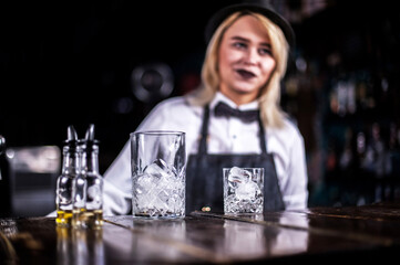 Sweet girl tapster adds ingredients to a cocktail