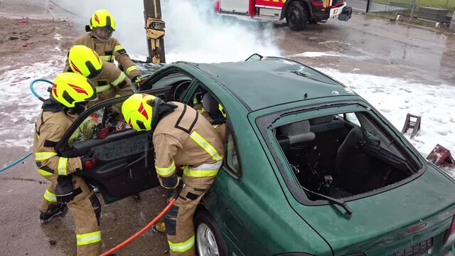 Firefighter cutting car doors with hydraulic cutter. Car accident. High quality 4k footage