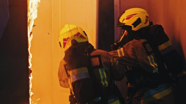 Firefighters breaking into the burning house. High quality 4k footage