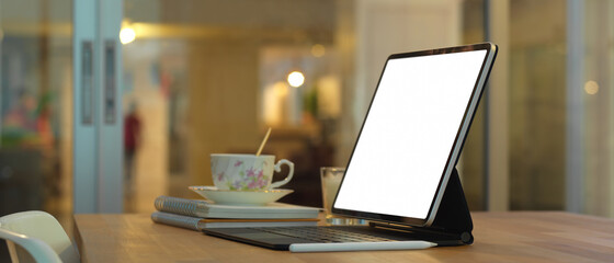 Female using smartphone while working with laptop in home office room