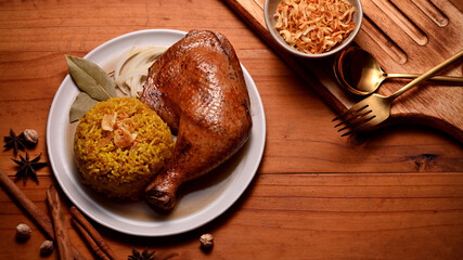 Delicious chicken biryani with rice marinated in spices serving with fried onion