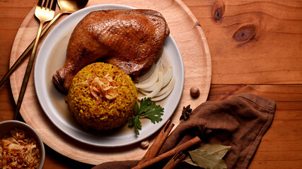 Delicious chicken biryani with rice marinated in spices on wooden table