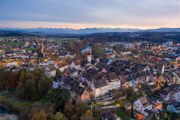 sunset over a medieval town with view of the alps