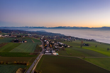 sunset over the alps , fog and a little village 