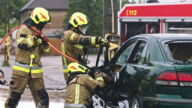 Firefighter beraking glass using jaws of life to extricate trapped victim from the car. High quality photo
