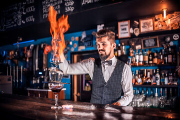 Barman concocts a cocktail behind the bar