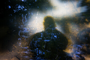 Shadow of a man on the water, black silhouette and water ripple of a forest river  © PhotoChur