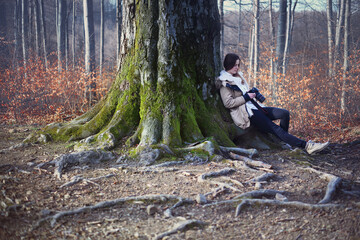 Young Caucasian female photographer in autumn foggy forest.
