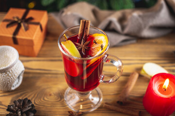 Cup of aromatic hot mulled wine on a wooden table. Concept of a festive atmosphere and traditional winter beverage