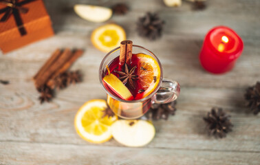Cup of aromatic hot mulled wine on a wooden table. Concept of a festive atmosphere and traditional...