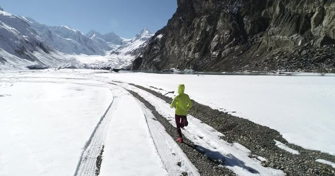 Woman trail runner cross country running in winter nature,Aerial view drone footage 