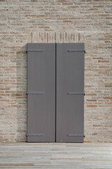 Brick wall with grey painted wooden shutter,  closed and blank window or door with space for text, perfect background