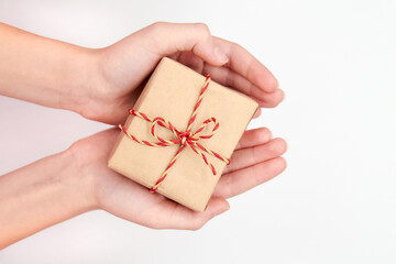 Girl holding in hands Christmas or New Year gift box against a light background