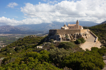 Fototapeta na wymiar Chapel of Notre Dame de la Serra Sitting High on a Hill Near the Town of Calvi in Corsica, France